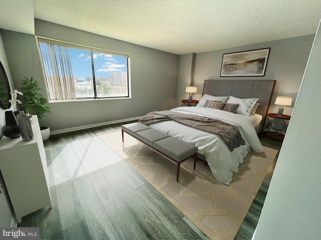 bedroom with wood finished floors, baseboards, and a textured ceiling