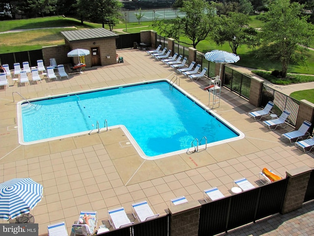 community pool featuring a patio and fence