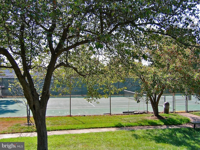 view of sport court with a yard and fence