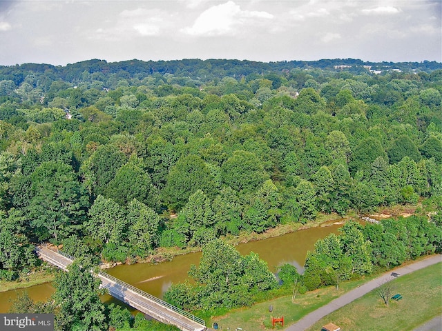 aerial view featuring a wooded view and a water view