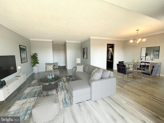 living area with crown molding, baseboards, a chandelier, wood finished floors, and a textured ceiling