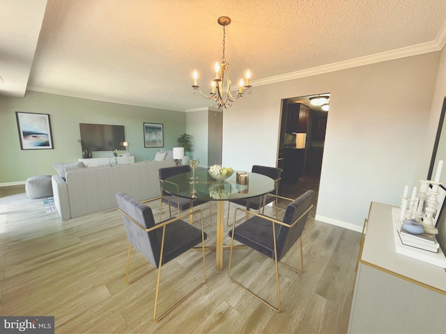 dining area featuring light wood finished floors, crown molding, baseboards, a chandelier, and a textured ceiling