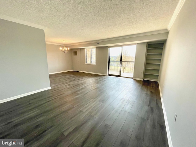 empty room featuring ornamental molding, a textured ceiling, an inviting chandelier, baseboards, and dark wood-style flooring