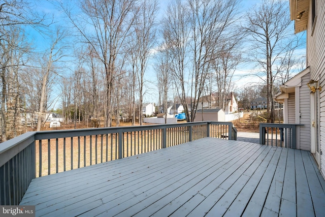 deck with an outdoor structure, a residential view, and a shed