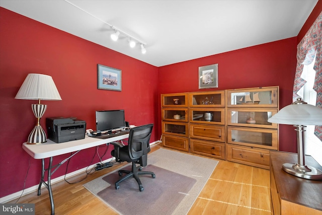 office space with baseboards, wood finished floors, and rail lighting