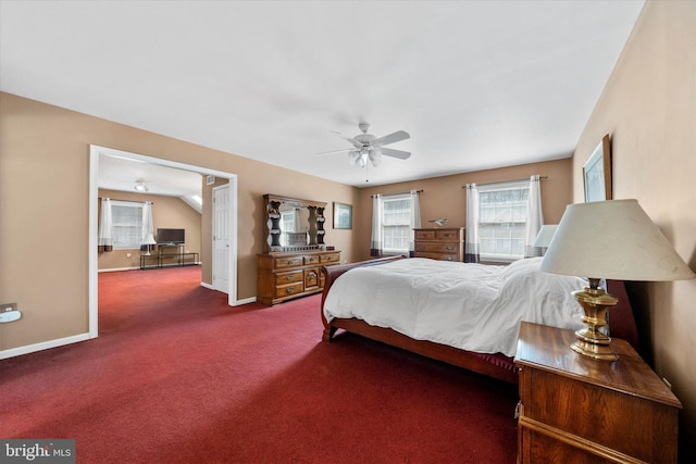 carpeted bedroom featuring baseboards, multiple windows, and ceiling fan