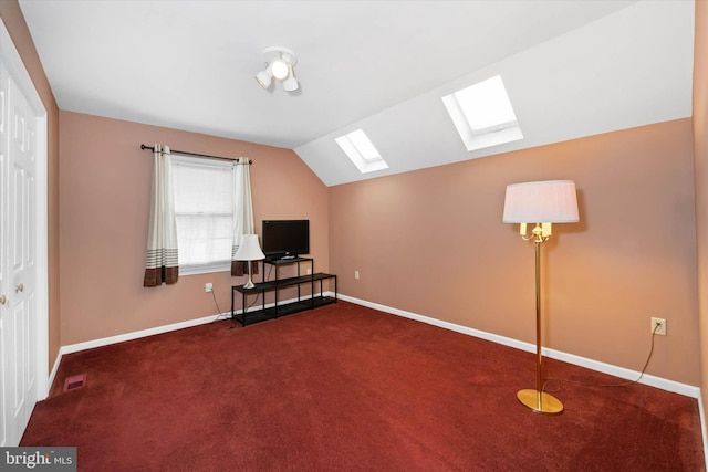 additional living space with visible vents, vaulted ceiling with skylight, carpet, and baseboards