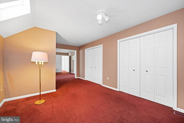 unfurnished bedroom featuring visible vents, multiple closets, carpet floors, and baseboards