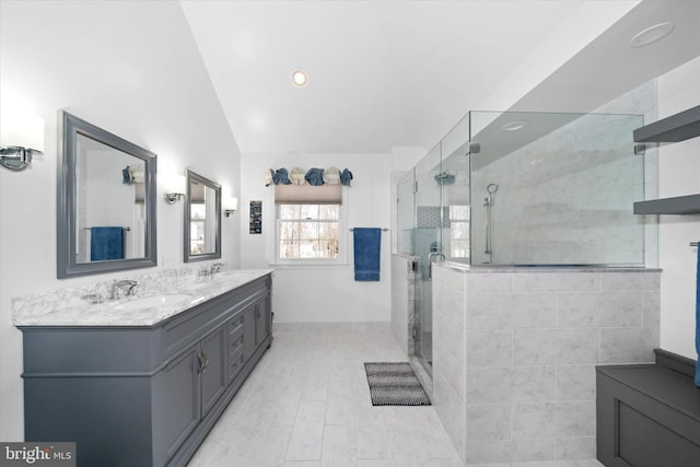 bathroom with double vanity, a stall shower, lofted ceiling, and a sink