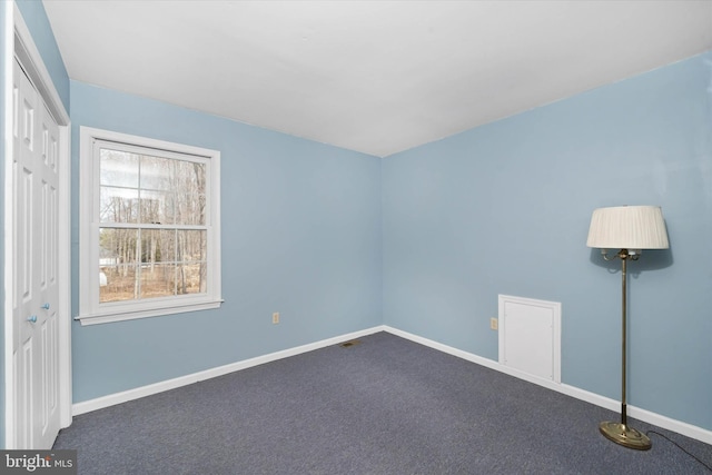 carpeted empty room with baseboards