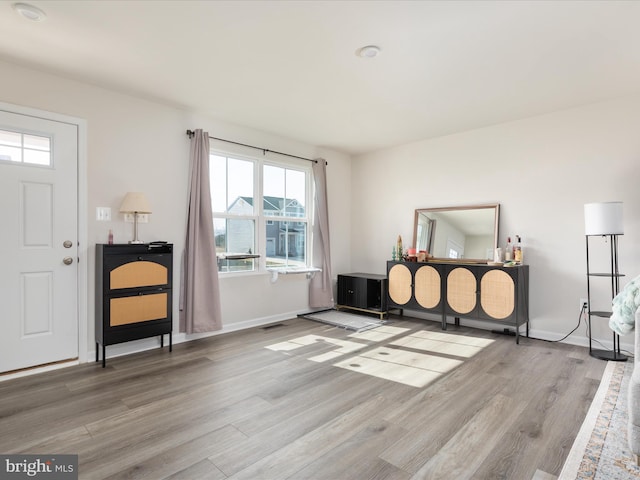 foyer entrance with visible vents, light wood-type flooring, and baseboards