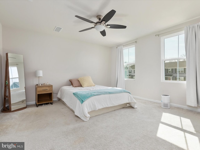 bedroom with a ceiling fan, visible vents, baseboards, and carpet floors