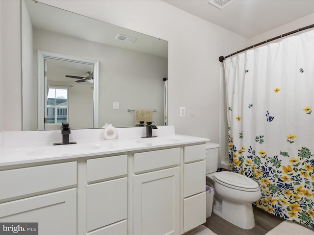 full bath with double vanity, toilet, visible vents, and a sink