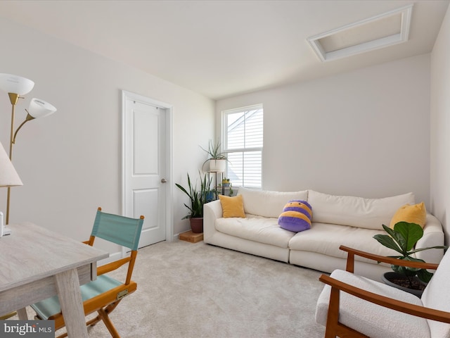 living area featuring attic access and carpet flooring