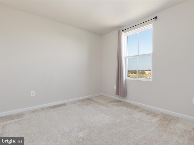 unfurnished room featuring carpet flooring and baseboards