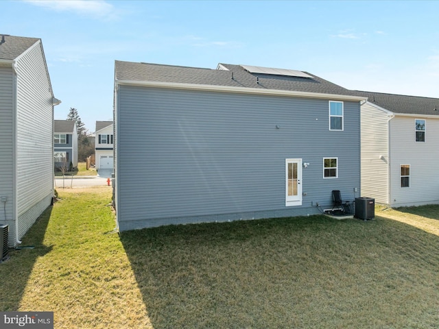 back of property featuring a lawn and cooling unit