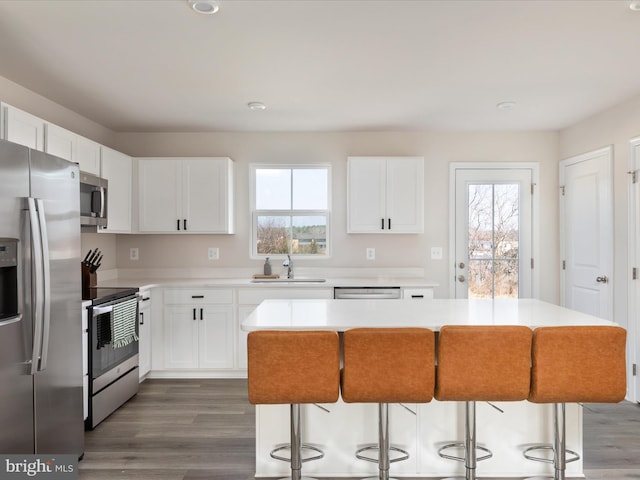 kitchen featuring a sink, light countertops, a breakfast bar area, and stainless steel appliances