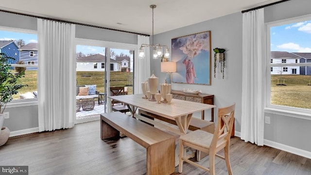 dining area with baseboards, plenty of natural light, and wood finished floors