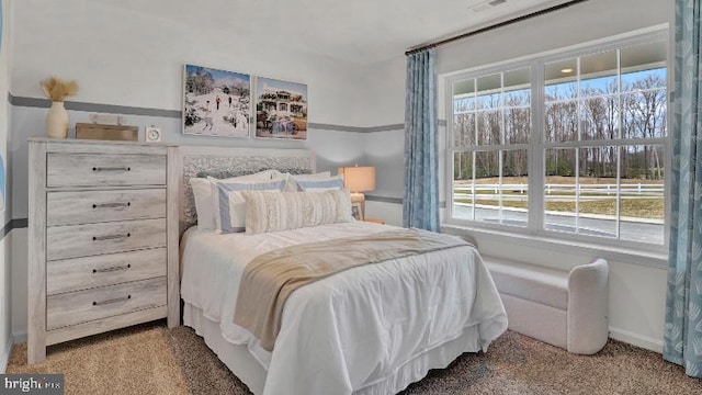 carpeted bedroom with visible vents and baseboards