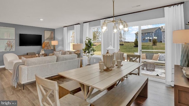 dining space with a notable chandelier and wood finished floors