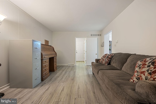 living room featuring light wood-type flooring, visible vents, and baseboards