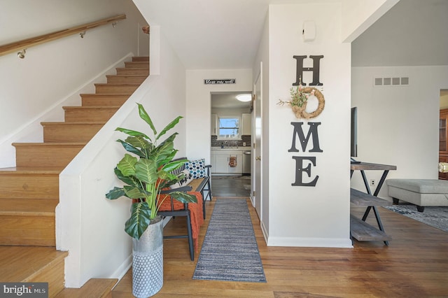 stairs featuring visible vents, baseboards, and wood finished floors