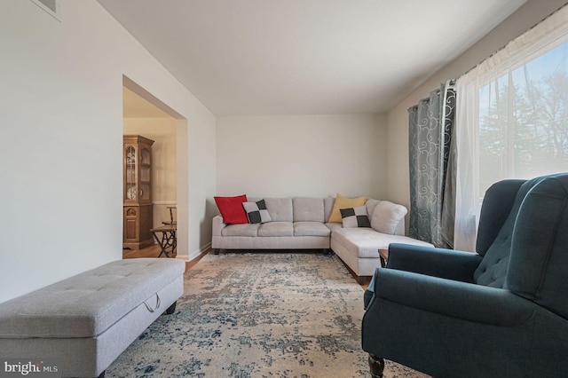 living room with wood finished floors, visible vents, and baseboards