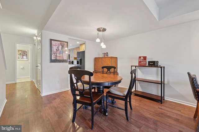 dining space with baseboards and wood finished floors