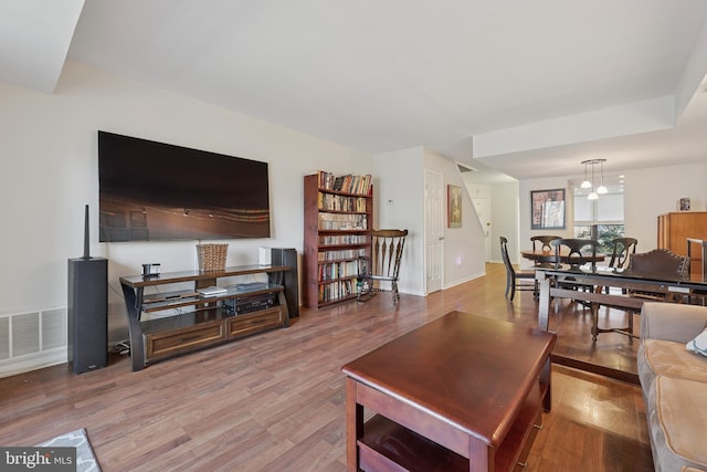 living area featuring visible vents and wood finished floors