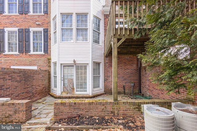 view of home's exterior with a patio, cooling unit, and brick siding