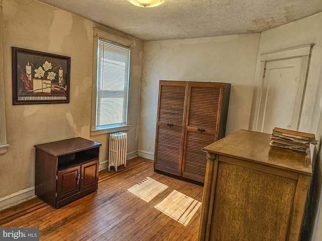 interior space with baseboards, dark wood-type flooring, and radiator heating unit