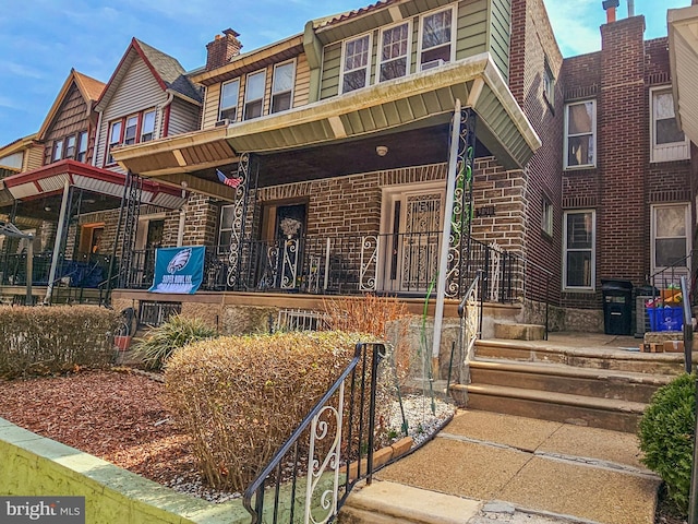 view of property with brick siding and covered porch