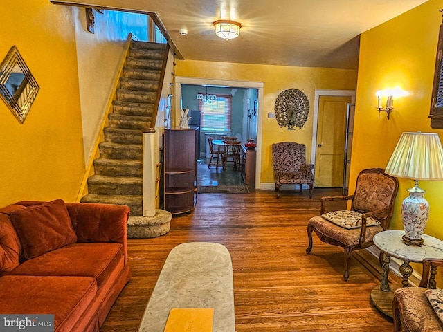 living area with stairway, baseboards, and wood finished floors