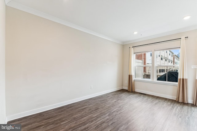 empty room with recessed lighting, dark wood-type flooring, baseboards, and ornamental molding