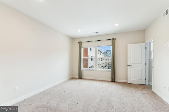 empty room with recessed lighting, carpet flooring, visible vents, and baseboards