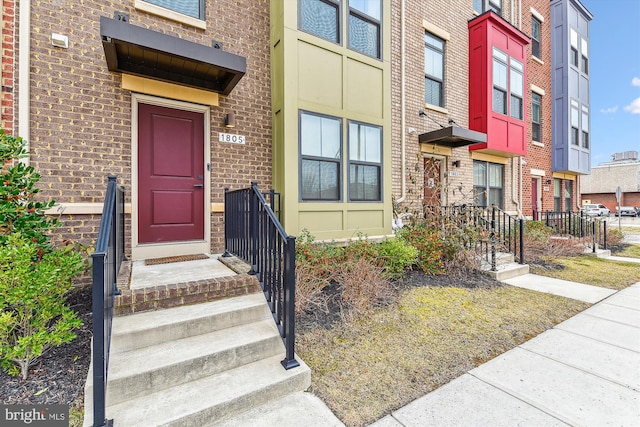 doorway to property with brick siding