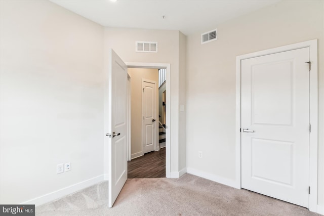 unfurnished bedroom featuring carpet flooring, baseboards, and visible vents