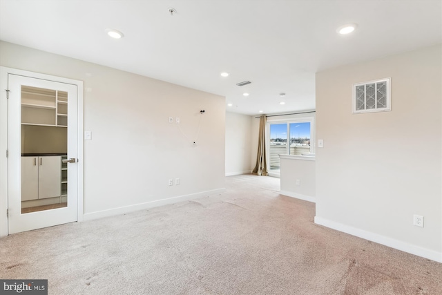 carpeted spare room with recessed lighting, visible vents, and baseboards