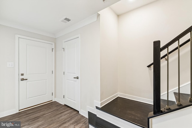 entrance foyer with visible vents, baseboards, wood finished floors, and ornamental molding