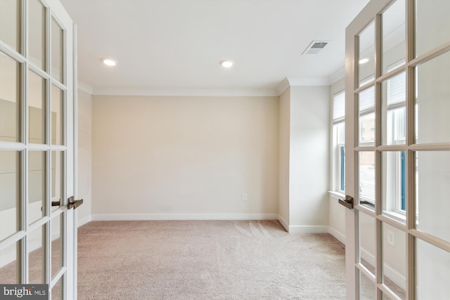 empty room featuring visible vents, crown molding, baseboards, and carpet floors