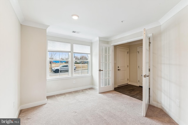 carpeted foyer with baseboards, french doors, visible vents, and ornamental molding