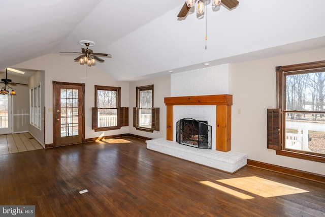 unfurnished living room featuring hardwood / wood-style flooring, baseboards, a brick fireplace, ceiling fan, and vaulted ceiling