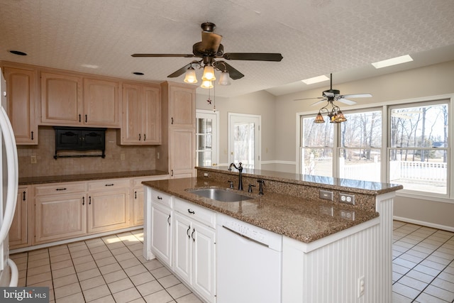 kitchen with light tile patterned floors, an island with sink, a sink, dishwasher, and backsplash