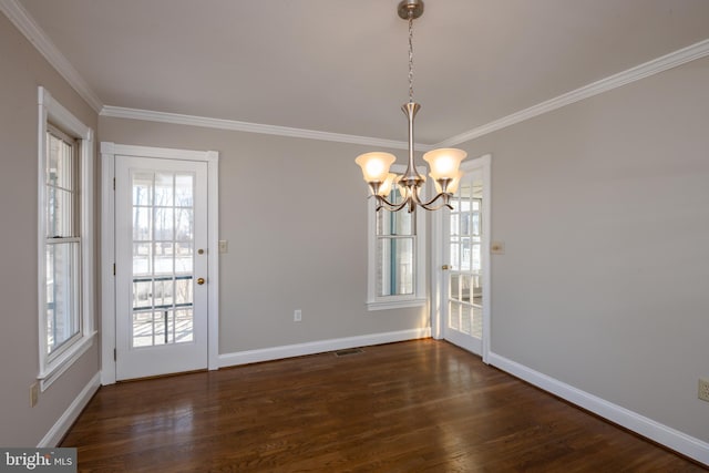 unfurnished dining area featuring crown molding, wood finished floors, baseboards, and a chandelier