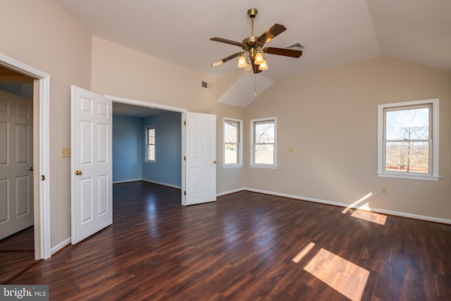 interior space featuring dark wood-type flooring, baseboards, visible vents, and vaulted ceiling