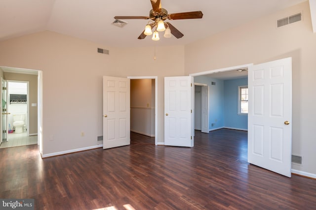 unfurnished bedroom with lofted ceiling, dark wood-style floors, and visible vents