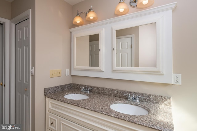 bathroom featuring a sink, a closet, and double vanity