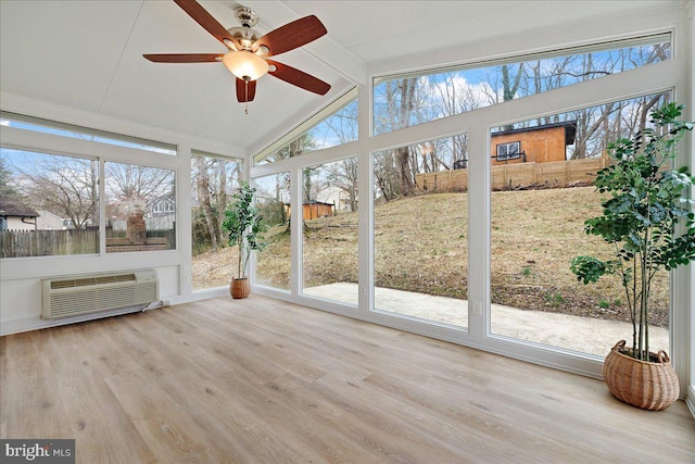 unfurnished sunroom featuring plenty of natural light, a ceiling fan, lofted ceiling with beams, and a wall unit AC