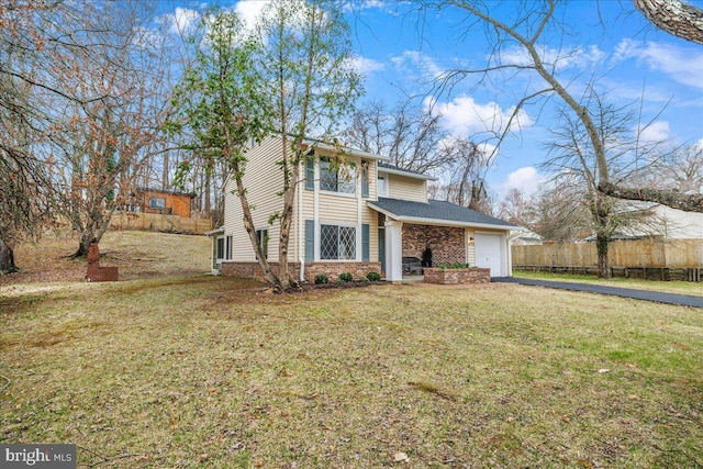 view of front of house featuring a front lawn, an attached garage, fence, and driveway