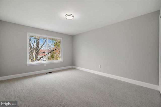 spare room featuring visible vents, baseboards, and carpet